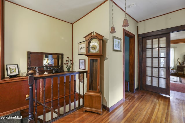 foyer featuring baseboards, ornamental molding, and wood finished floors