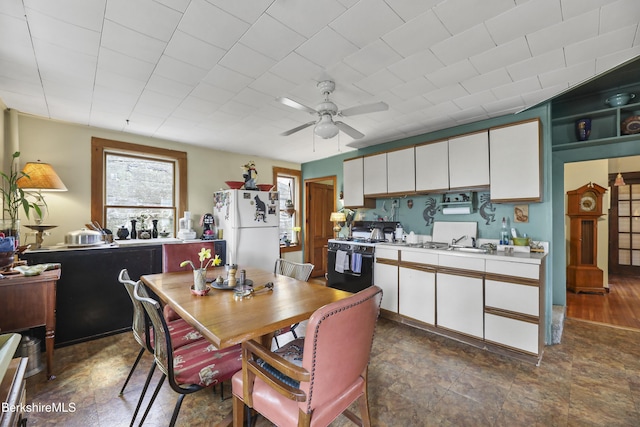 kitchen with gas stove, freestanding refrigerator, a wealth of natural light, and light countertops