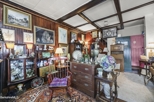 sitting room with wood walls and beamed ceiling