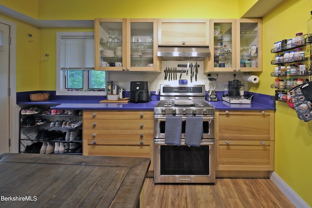 88 Newell St, Pittsfield, MA 01201 - kitchen featuring range with two ovens, extractor fan, dark countertops, wood finished floors, and glass insert cabinets