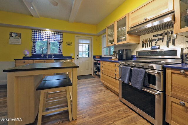 88 Newell St, Pittsfield, MA 01201 - kitchen featuring double oven range, under cabinet range hood, dark countertops, wood finished floors, and beamed ceiling