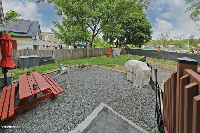 88 Newell St, Pittsfield, MA 01201 - fenced backyard featuring a playground and an outdoor fire pit