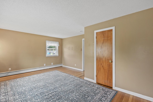 36 Dalton Division Rd, Dalton, MA 01226 - empty room with wood finished floors, a baseboard heating unit, and a textured ceiling