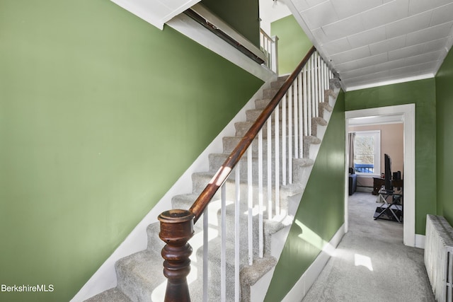 staircase featuring carpet and radiator heating unit