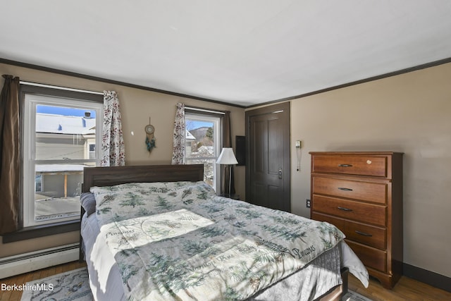 bedroom with multiple windows, a baseboard heating unit, crown molding, and dark wood-type flooring