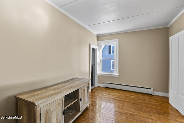 interior space with crown molding, light hardwood / wood-style floors, and a baseboard heating unit