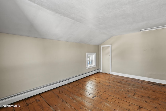 additional living space featuring hardwood / wood-style flooring, a baseboard radiator, vaulted ceiling, and a textured ceiling