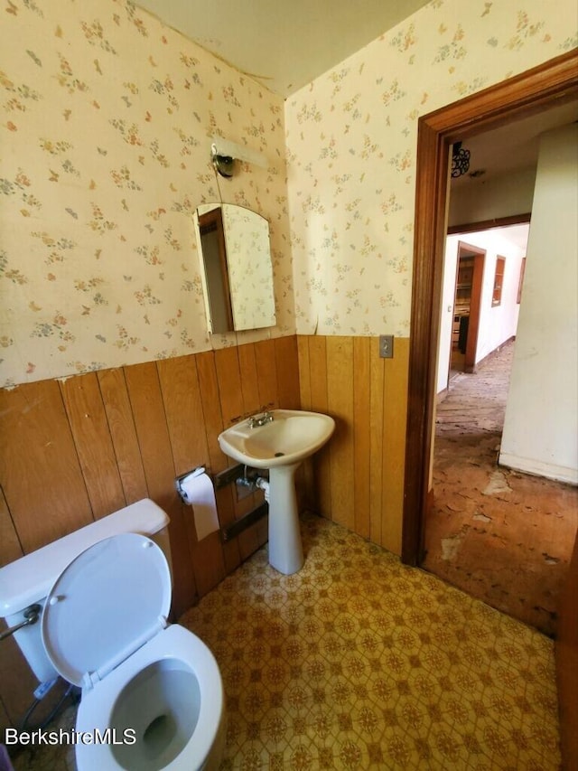 bathroom featuring toilet and wooden walls