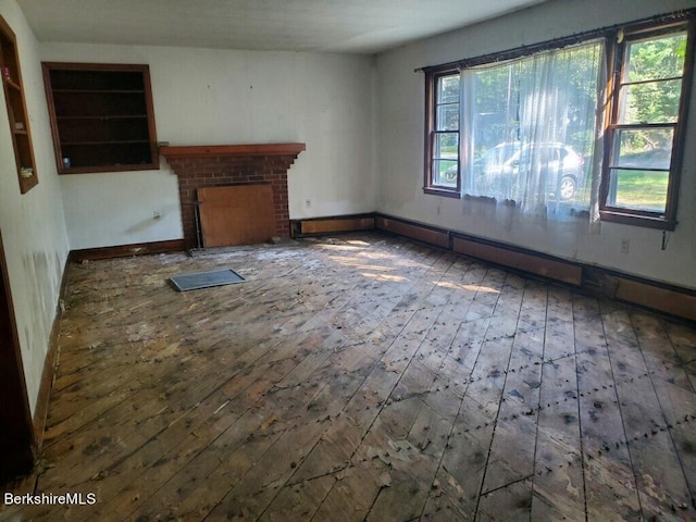 unfurnished living room with dark hardwood / wood-style floors and a brick fireplace