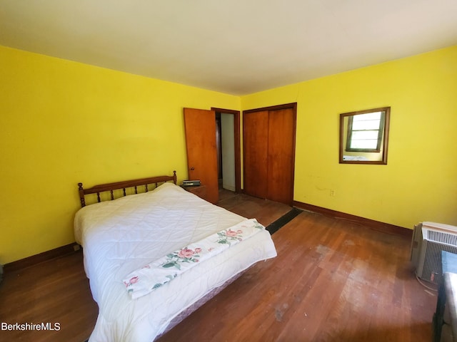 bedroom with dark hardwood / wood-style floors and a closet