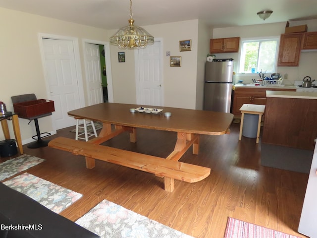 dining area with dark hardwood / wood-style floors and a notable chandelier