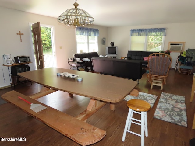 dining space with dark hardwood / wood-style flooring, plenty of natural light, and a notable chandelier