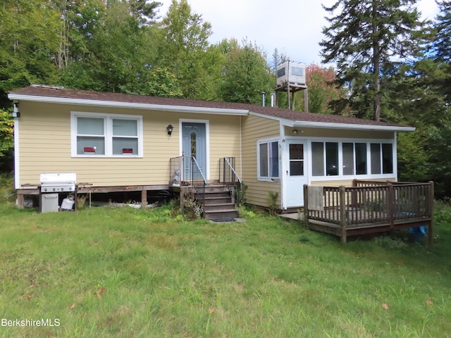 view of front of house featuring a sunroom, a front yard, and a deck