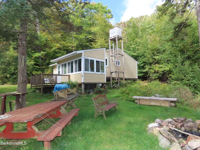 back of property with a sunroom and a wooden deck