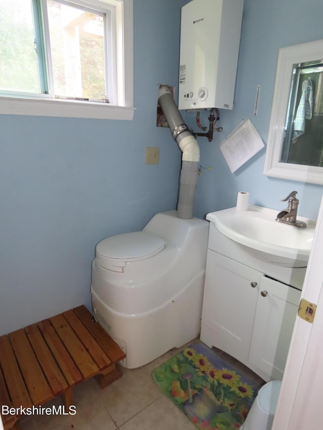 bathroom with tile patterned flooring, vanity, toilet, and water heater