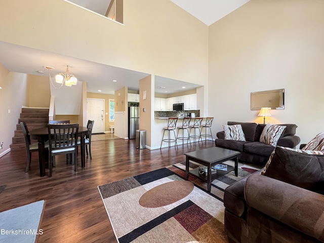 9253 Mountainside Dr, Hancock, MA 01237 - living room featuring an inviting chandelier, dark wood-style flooring, stairs, and baseboards