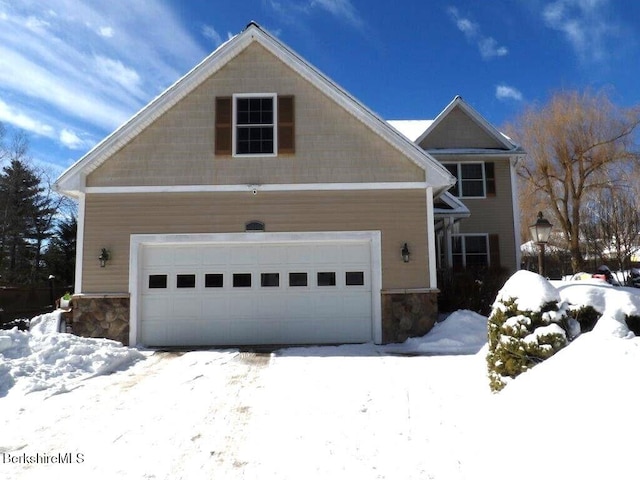 view of front of property with a garage and stone siding