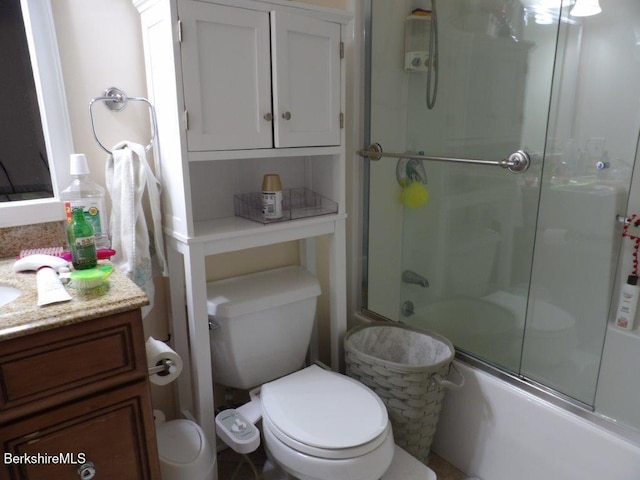 full bathroom with bath / shower combo with glass door, vanity, and toilet