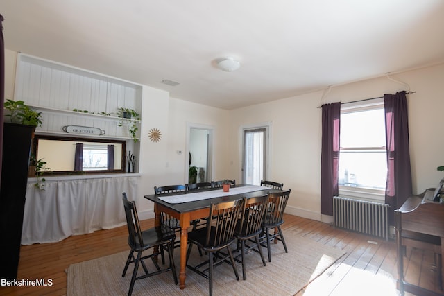 dining area featuring radiator heating unit and hardwood / wood-style floors