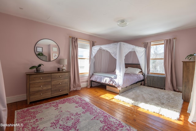 bedroom with radiator and light hardwood / wood-style flooring