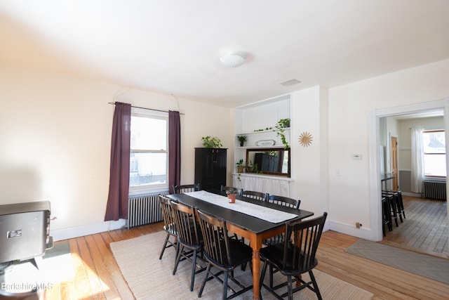 dining space featuring radiator heating unit and light wood-type flooring