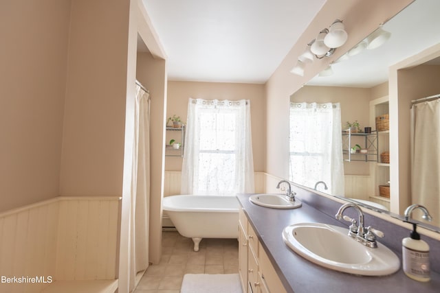 bathroom featuring tile patterned flooring, vanity, and a tub