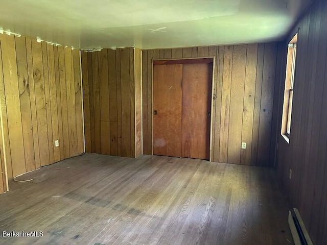 425 Barbour St, North Adams, MA 01247 - unfurnished bedroom with a baseboard radiator, wood finished floors, and wood walls