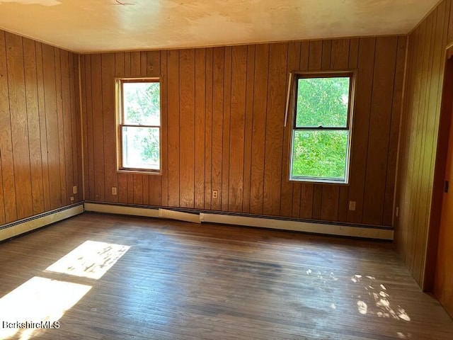 425 Barbour St, North Adams, MA 01247 - spare room with hardwood / wood-style floors, wooden walls, and a baseboard radiator