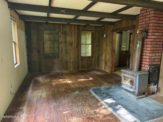 425 Barbour St, North Adams, MA 01247 - unfurnished living room featuring plenty of natural light, a wood stove, coffered ceiling, wood walls, and beam ceiling