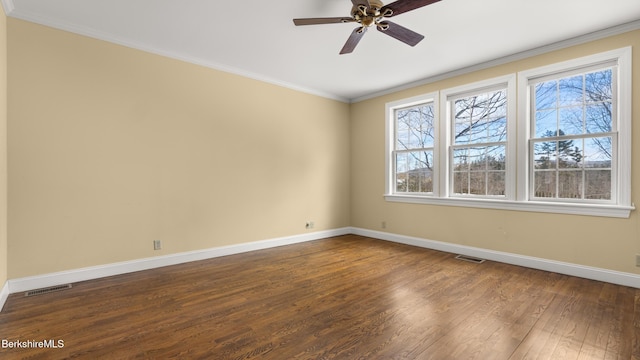 empty room with dark wood-style floors, visible vents, ornamental molding, and baseboards