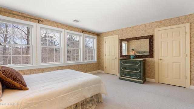 bedroom with baseboards, light colored carpet, and wallpapered walls