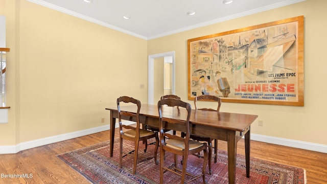 dining room with baseboards, ornamental molding, wood finished floors, and recessed lighting