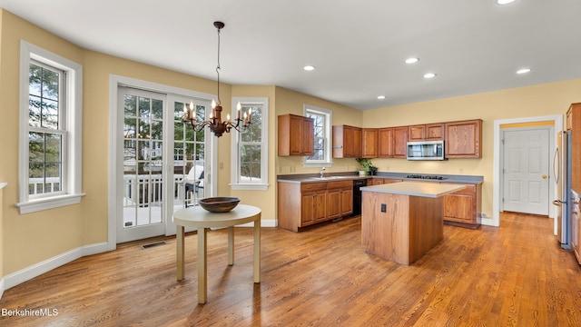 kitchen featuring appliances with stainless steel finishes, a center island, and light wood finished floors