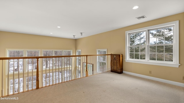 unfurnished room with carpet, recessed lighting, visible vents, and baseboards