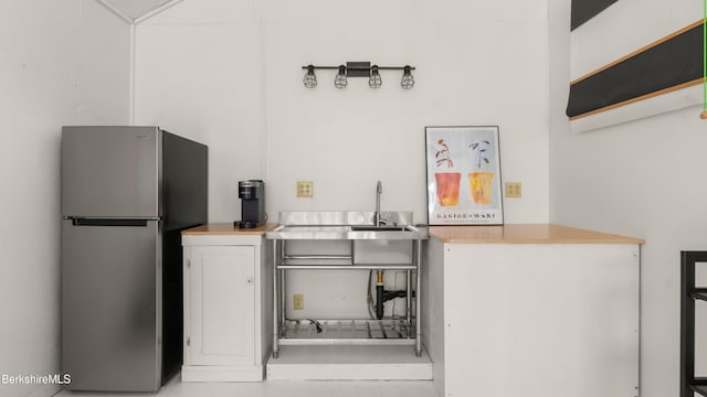 kitchen with a sink and freestanding refrigerator