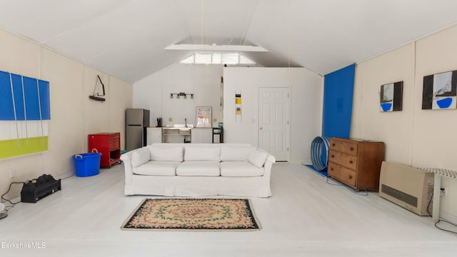 living room featuring lofted ceiling and a decorative wall