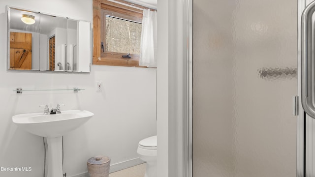 bathroom with a stall shower and toilet