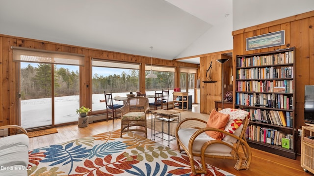 sitting room featuring high vaulted ceiling, wood walls, and wood finished floors