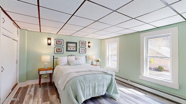 208 Columbia St, Adams, MA 01220 - bedroom with a baseboard radiator, wood finished floors, a paneled ceiling, and multiple windows