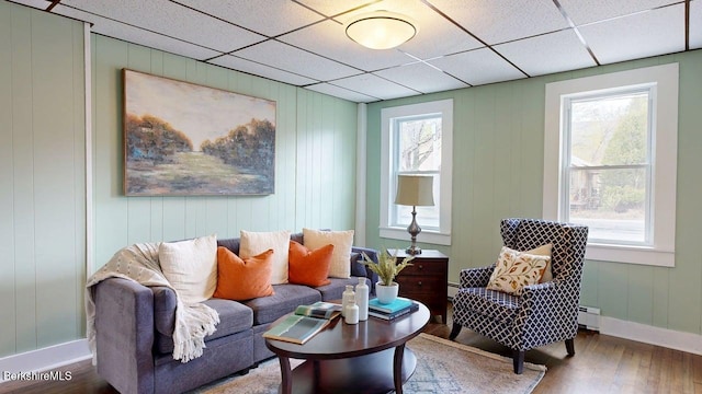 208 Columbia St, Adams, MA 01220 - living area featuring a baseboard radiator, wood finished floors, a drop ceiling, and baseboards