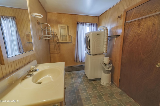 bathroom featuring sink, ornamental molding, and wood walls