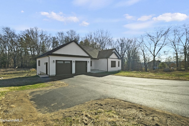 view of home's exterior with a garage and a lawn