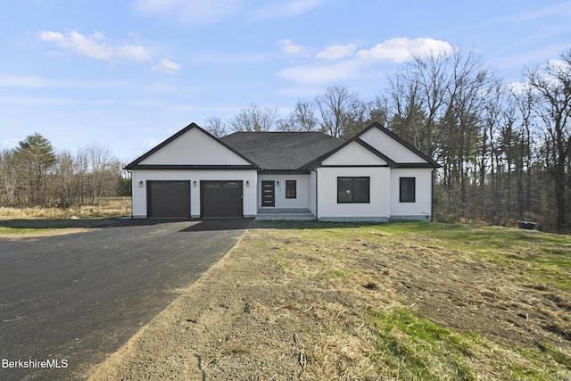 modern farmhouse with a garage and a front lawn