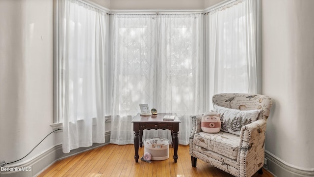 living area featuring baseboards and hardwood / wood-style floors