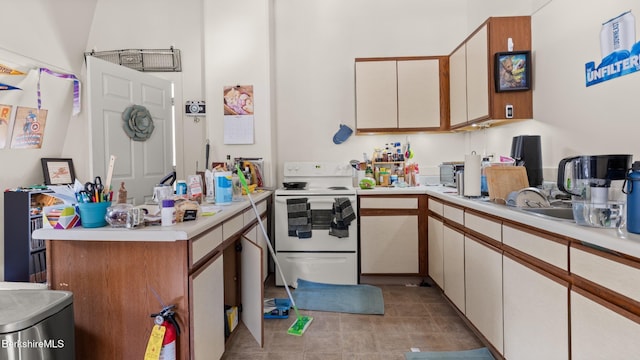 kitchen with tile patterned flooring, light countertops, white electric stove, and a peninsula