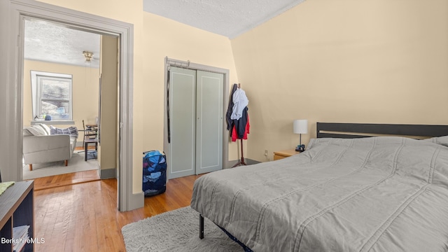 bedroom with a closet, a textured ceiling, and wood finished floors