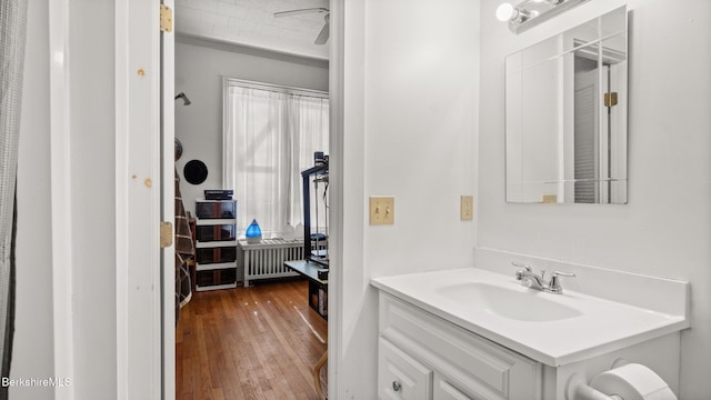 bathroom with vanity, radiator heating unit, and wood finished floors