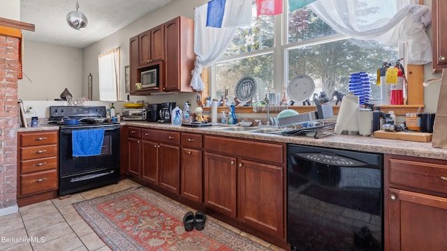 kitchen with light countertops, a sink, black appliances, and light tile patterned floors