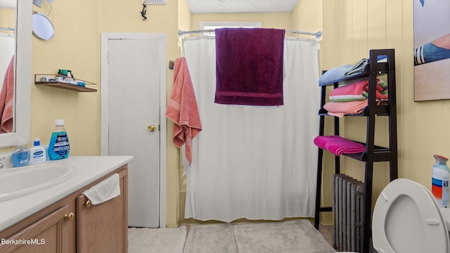 full bathroom featuring radiator heating unit, vanity, and tile patterned floors