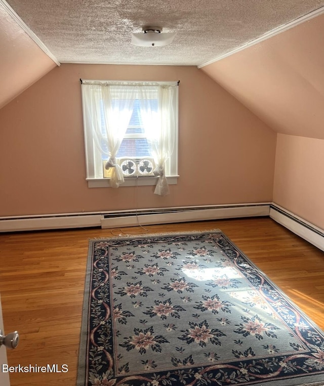 bonus room with a textured ceiling, lofted ceiling, light wood-type flooring, and a baseboard heating unit